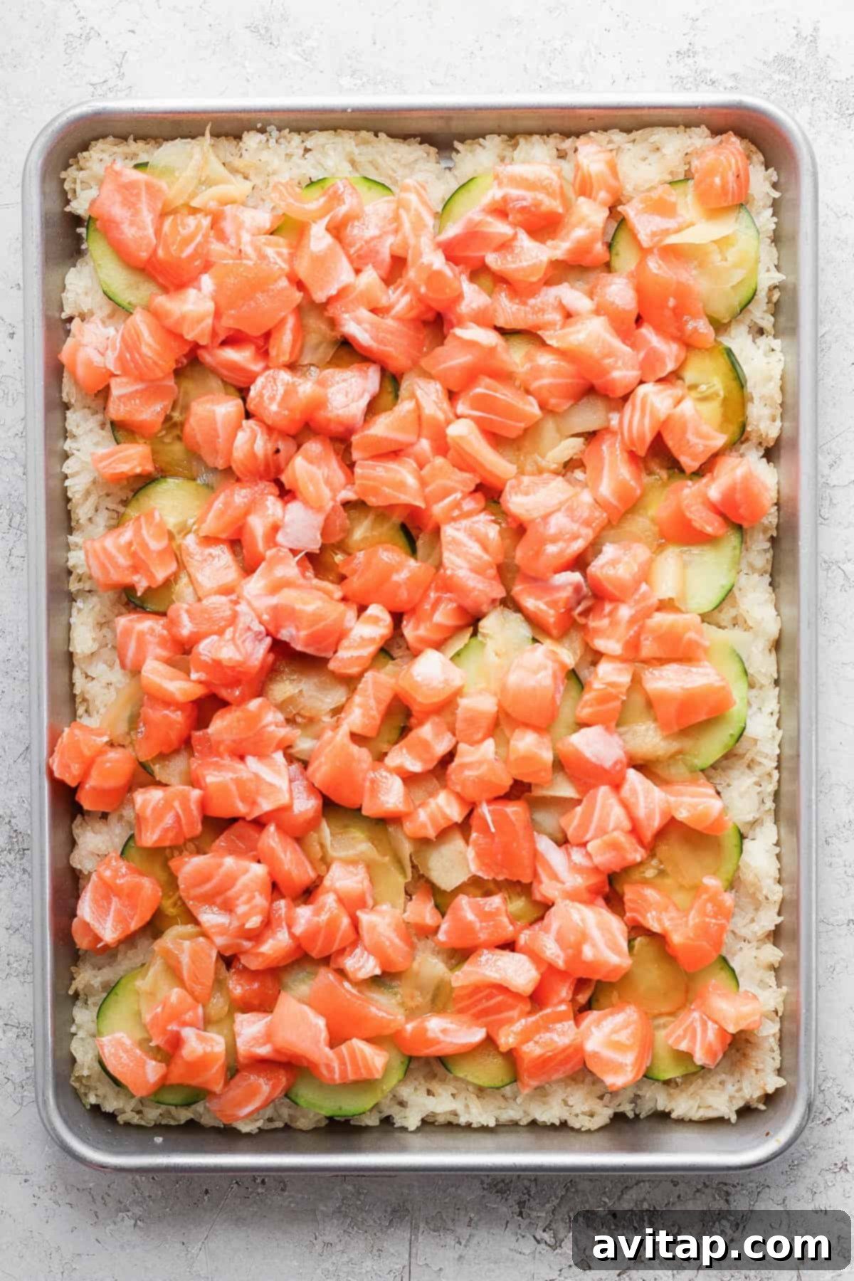 A fully assembled sheet pan crispy rice dish with salmon, nori salad, and Kewpie mayo, resembling a large sushi pizza.