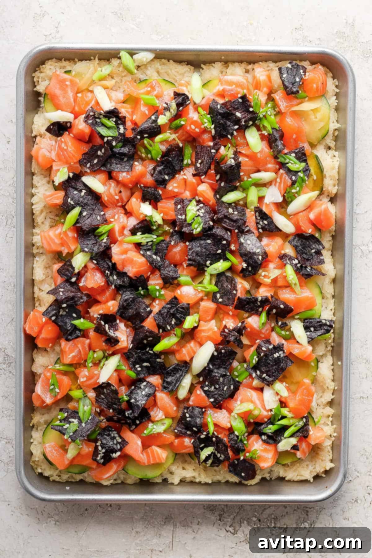 A close-up of a portion of the sheet pan crispy rice with salmon and onions, showcasing the textures.