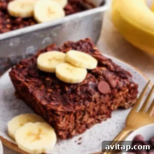 A plate of warm chocolate banana baked oatmeal with fresh banana slices on top.