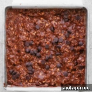 A baking pan filled with golden-brown chocolate banana baked oatmeal slices.