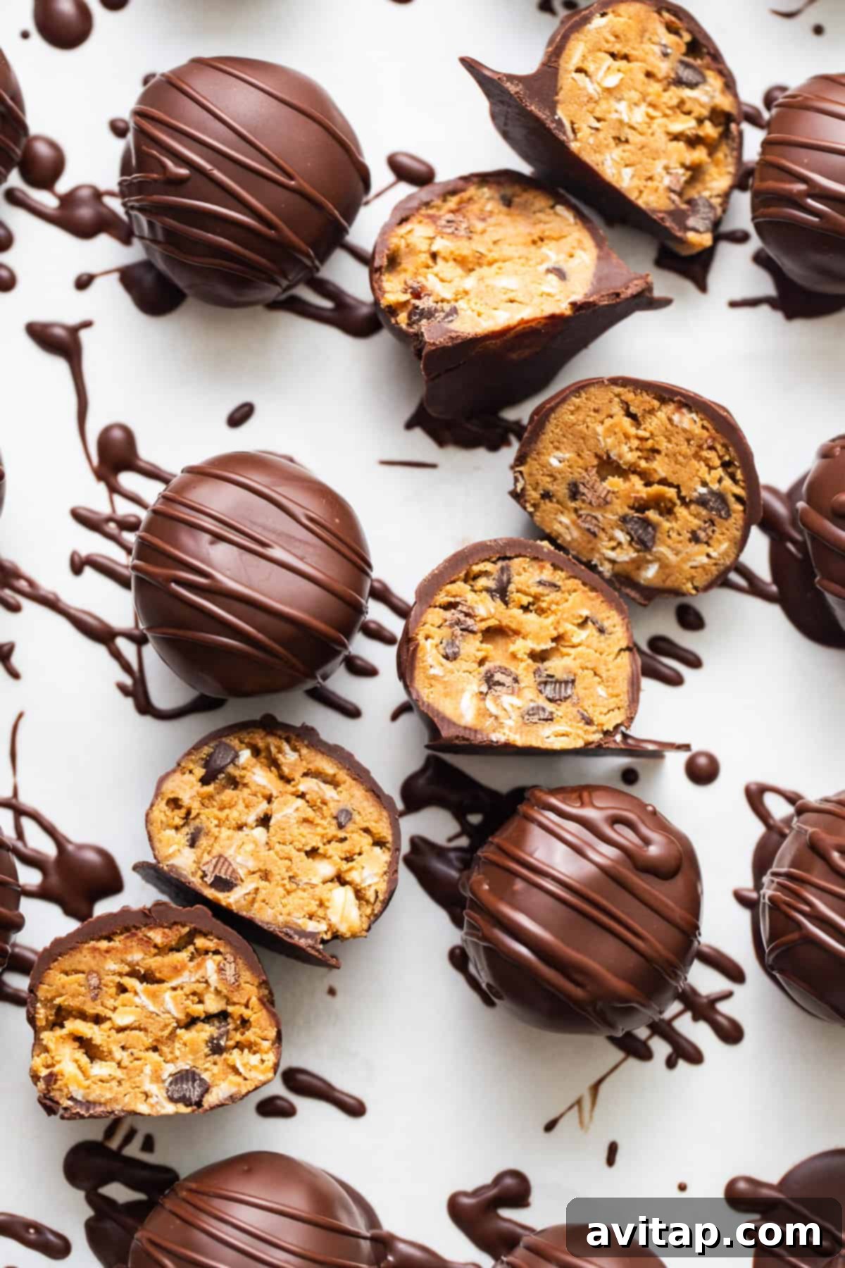 Irresistible chocolate-covered protein cookie dough truffles arranged beautifully on a white surface, showcasing their delicious appeal.