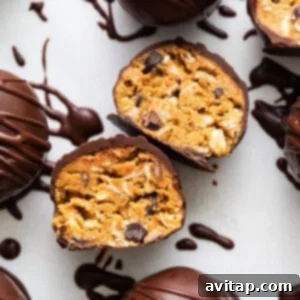 Chocolate covered peanut butter truffles on a white surface, showcasing the finished product.