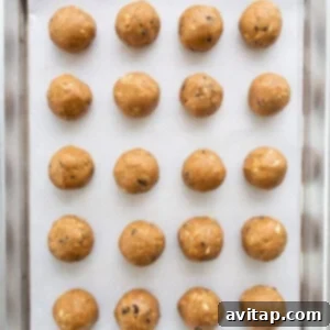 Peanut butter balls neatly arranged on a baking sheet, ready for the next step.