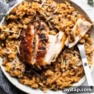 Chicken risotto with mushrooms and thyme on a plate, beautifully garnished.