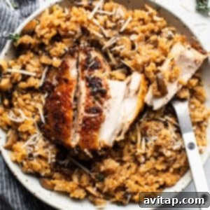 A bowl of rice with chicken and mushrooms, garnished with fresh herbs.