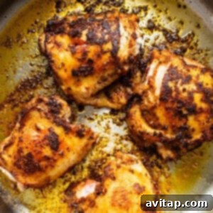 Roasted chicken in a skillet on a white background, sizzling with flavor.