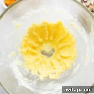 Zesty Orange Sunshine Cake 11 A glass bowl containing white powdered sugar, orange zest, and almond extract for the glaze.