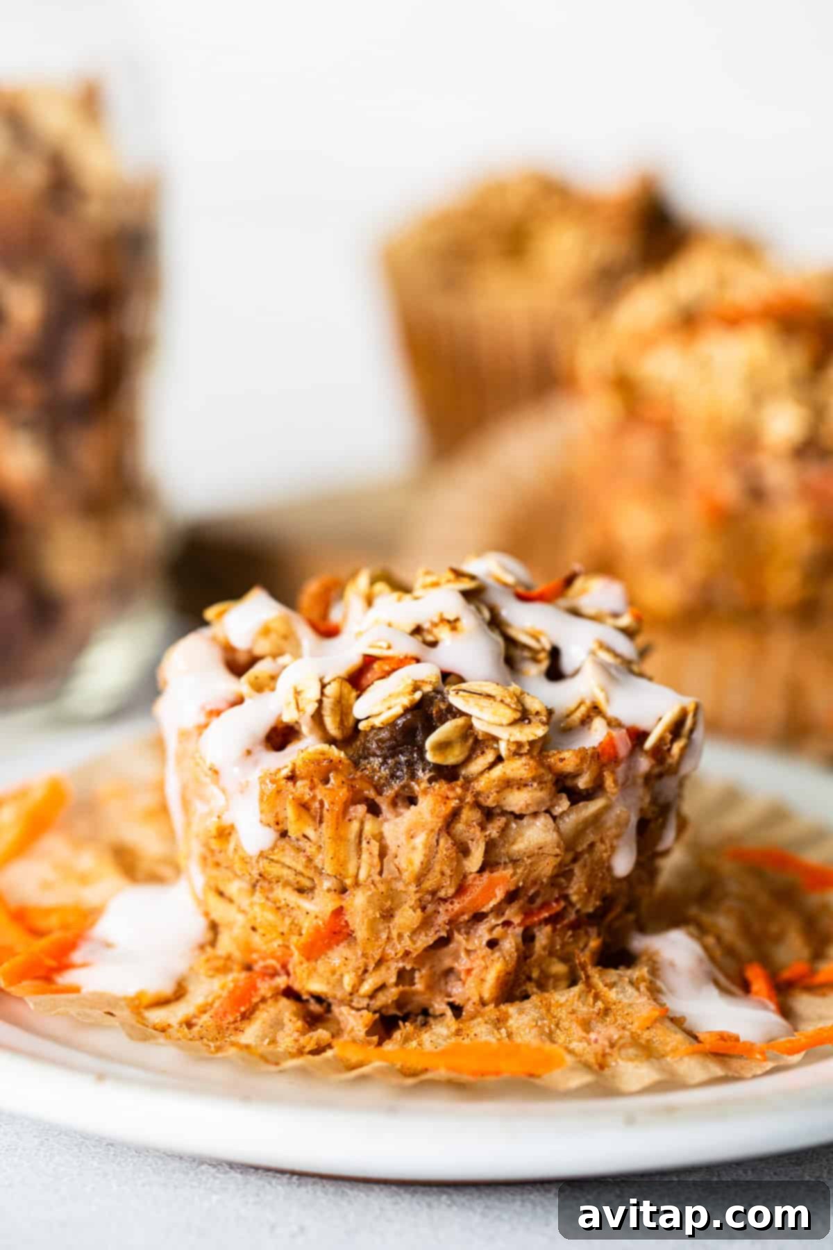 Spiced Carrot Cake Oatmeal Cups 5 Carrot granola muffins on a white plate.