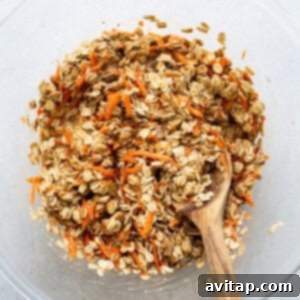 Spiced Carrot Cake Oatmeal Cups 8 Oats in a bowl with a wooden spoon.