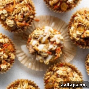 Spiced Carrot Cake Oatmeal Cups 9 A group of granola muffins on a white surface.