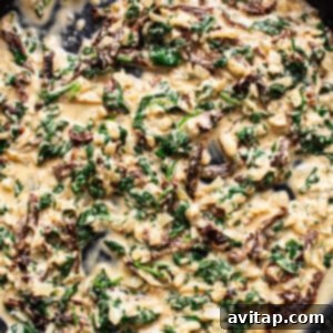 A skillet filled with spinach and mushrooms.