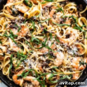 A skillet filled with pasta and shrimp.
