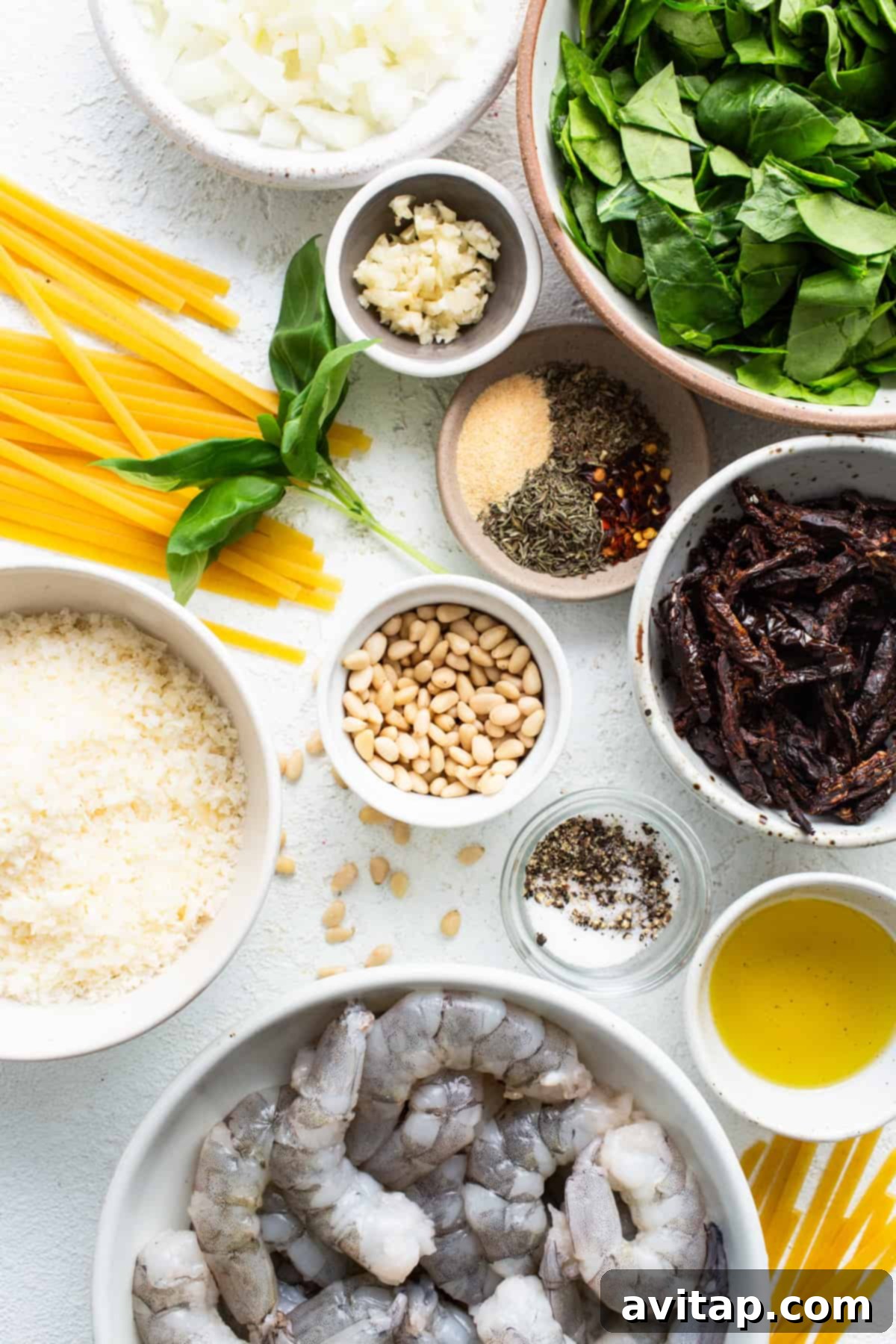 Ingredients for a pasta dish with shrimp and spinach.