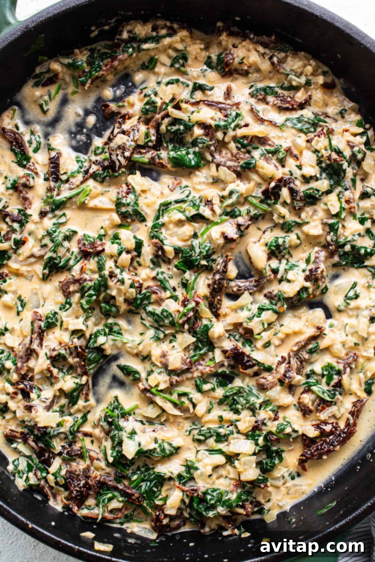 A skillet filled with spinach and mushrooms.