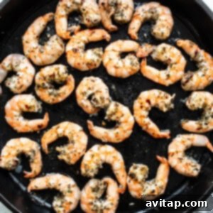 Grilled shrimp in a skillet with herbs.