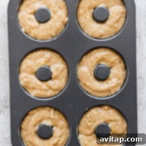 Banana Bread Ring Treats 12 A six-cavity donut baking pan filled with raw donut batter, ready to be baked.