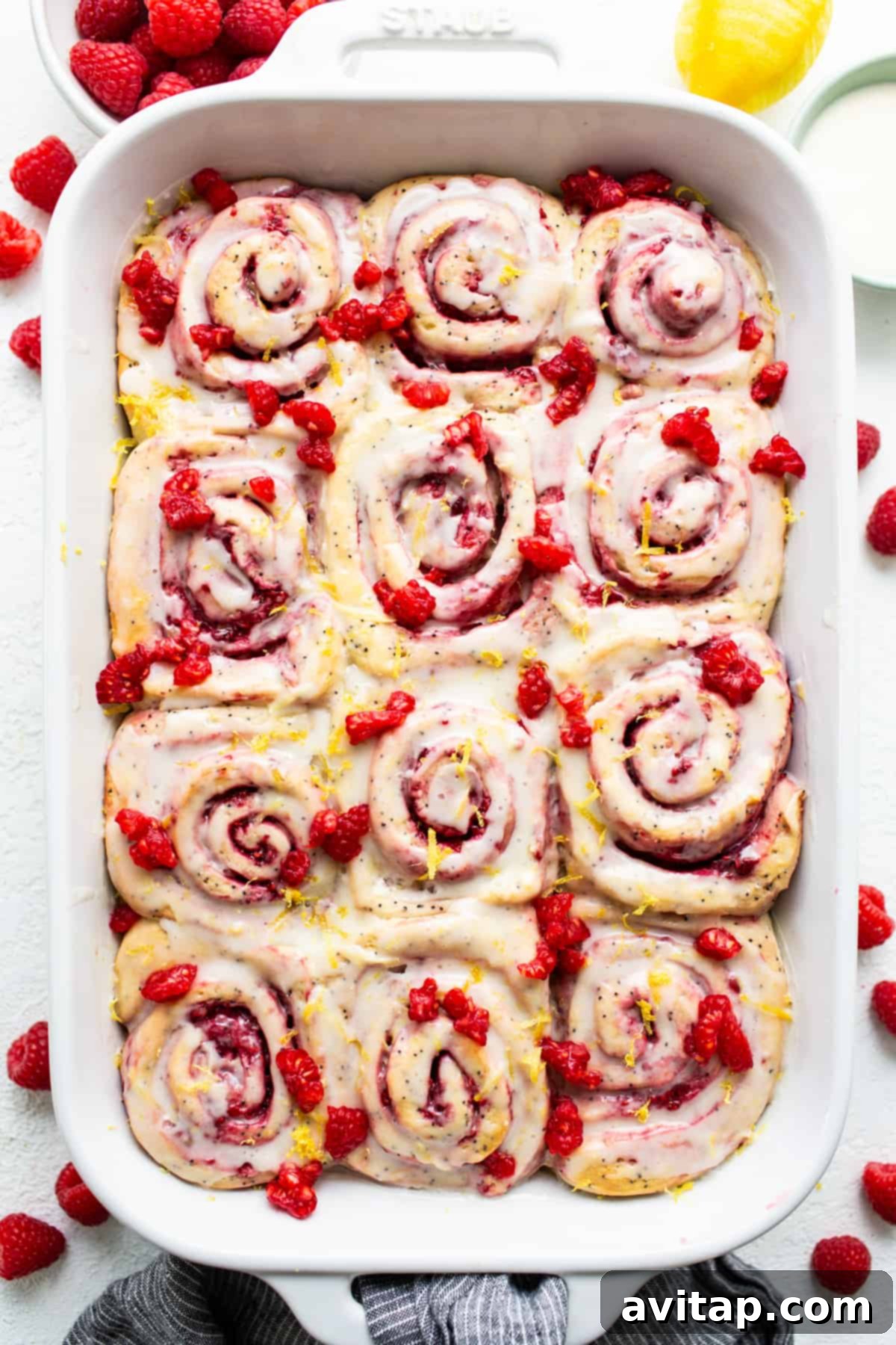 Raspberry lemon poppy seed rolls in a white baking dish, ready to be served.