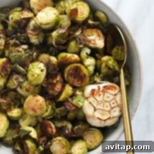 Roasted brussels sprouts in a glass bowl, garnished.