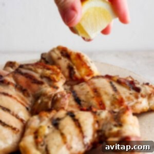 Squeezing lemon juice over grilled chicken breasts.