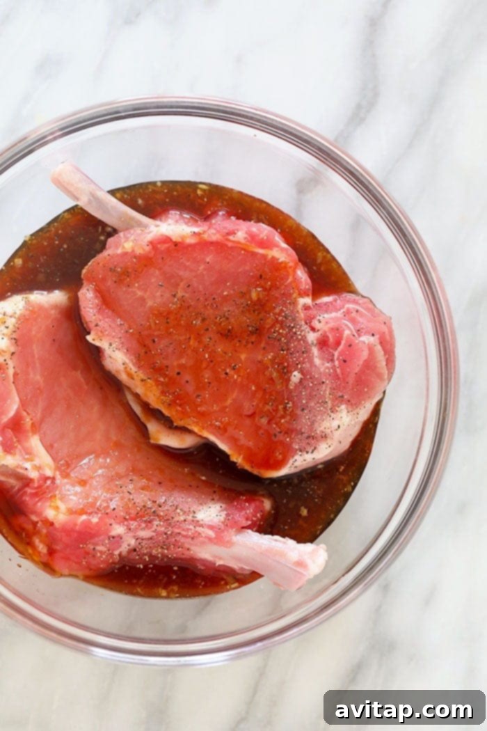 pork chops marinating in a glass bowl, ready for cooking