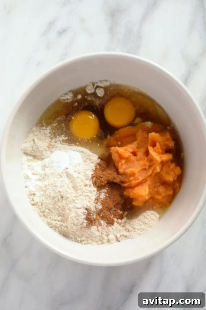 Dry ingredients for sweet potato pancakes mixed in a large ceramic bowl.
