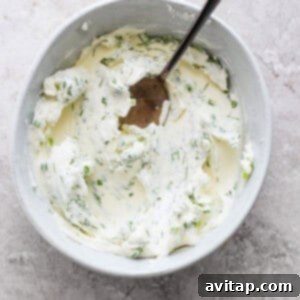 A bowl of herb cream cheese spread, mixed with fresh dill and chives, ready for the burritos.