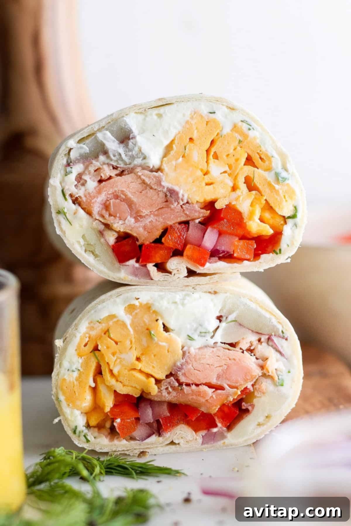 A freshly prepared smoked salmon breakfast burrito, wrapped in foil and ready to be enjoyed, showcasing the vibrant fillings within.