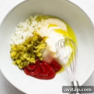 Preparing creamy homemade burger sauce in a bowl with a spoon, showing a mix of mayonnaise, ketchup, and other ingredients.