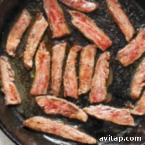 Slices of cooked meat in a black skillet.