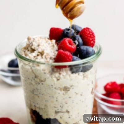 A jar of blended cottage cheese overnight oats, topped with fresh blueberries and a spoon, ready for a grab-and-go breakfast.
