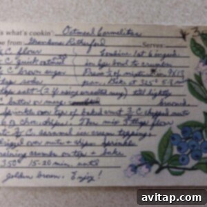 A beautifully handwritten recipe card for Carmelita bars with clear, step-by-step instructions and an elegant blue floral illustration on the right, signifying a treasured family recipe.