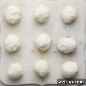 Nine perfectly shaped dough balls arranged in a 3x3 grid on a floured surface, ready for the air fryer.