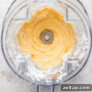 Top view of a blender with creamy, whipped mixture inside, surrounded by a dusting of white powder on the container's edges.