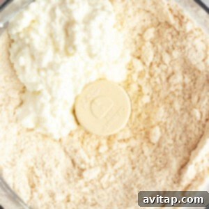 Fit Frosted Pastries 9 A food processor bowl filled with flour, butter, and cottage cheese, ready for blending into dough.