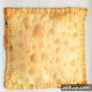Fit Frosted Pastries 13 A freshly baked, golden-brown rectangular pie with crimped edges and small perforations on top, resting on parchment paper after baking.