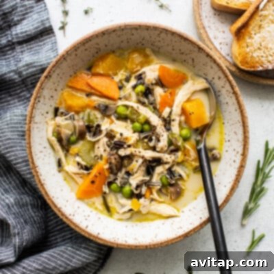 A comforting bowl of creamy turkey soup with wild rice and colorful vegetables.