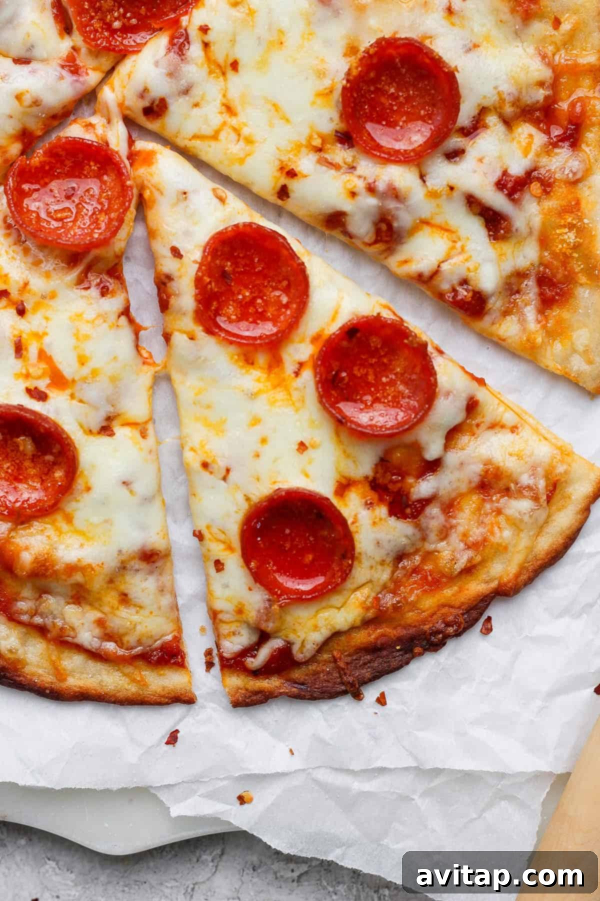 Quick 4 Ingredient Protein Pizza Dough 2 Slices of pepperoni pizza with melted cheese on parchment paper.