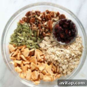 Dry ingredients for apple cinnamon granola in a bowl, ready to be mixed with wet ingredients.