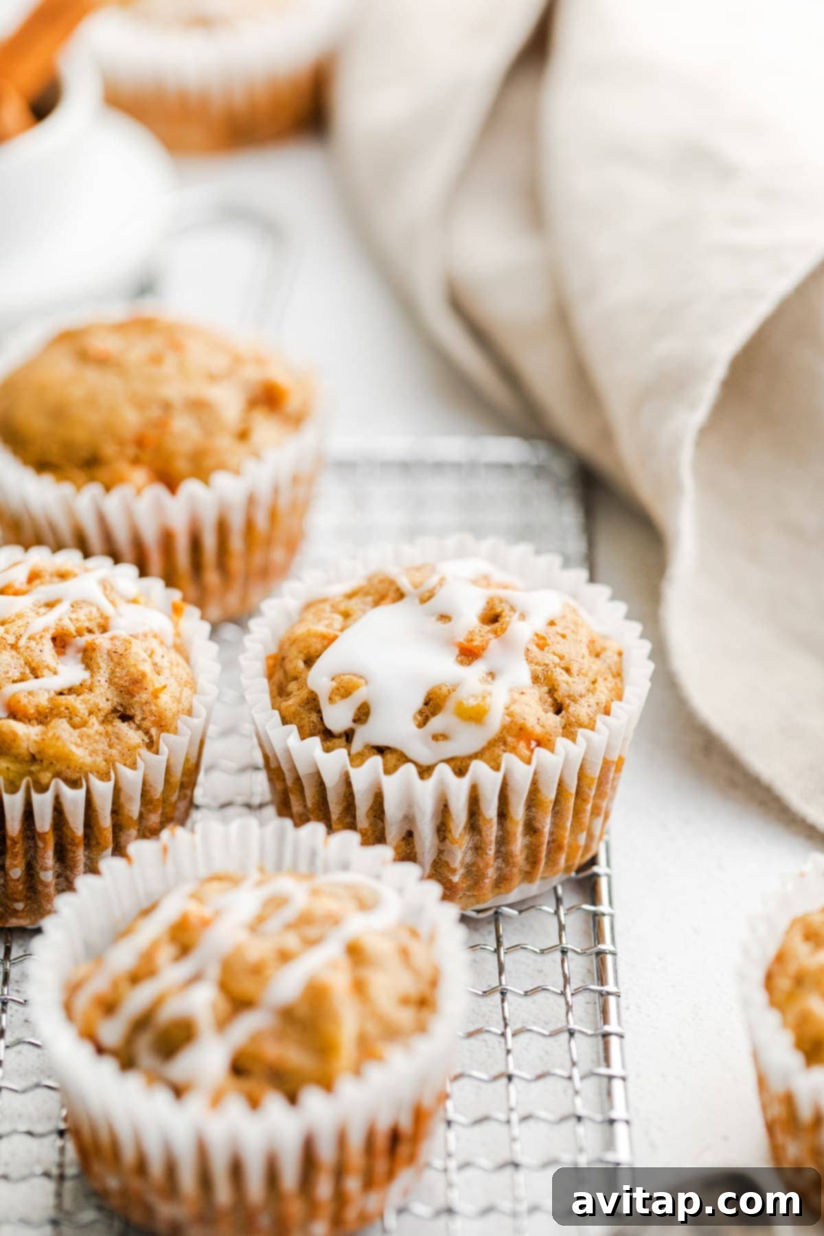 A basket full of freshly baked, unglazed carrot cake muffins, ready to be enjoyed or stored.