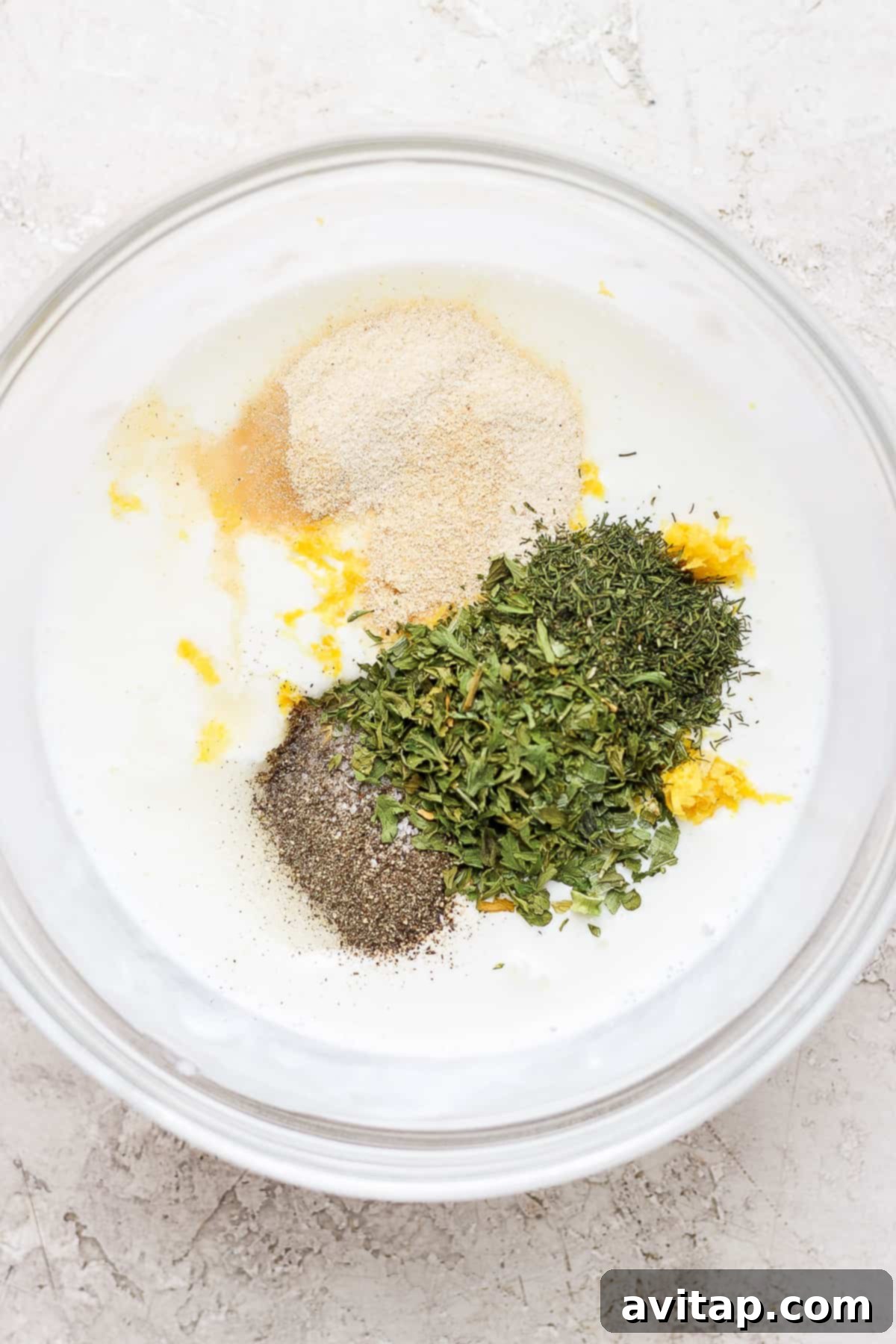 Close-up of ranch dressing ingredients combined in a mixing bowl before whisking.