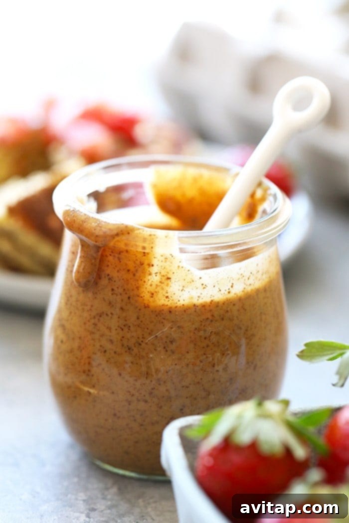 A jar of smooth almond butter with a spoon, highlighting healthy fats for breakfast.