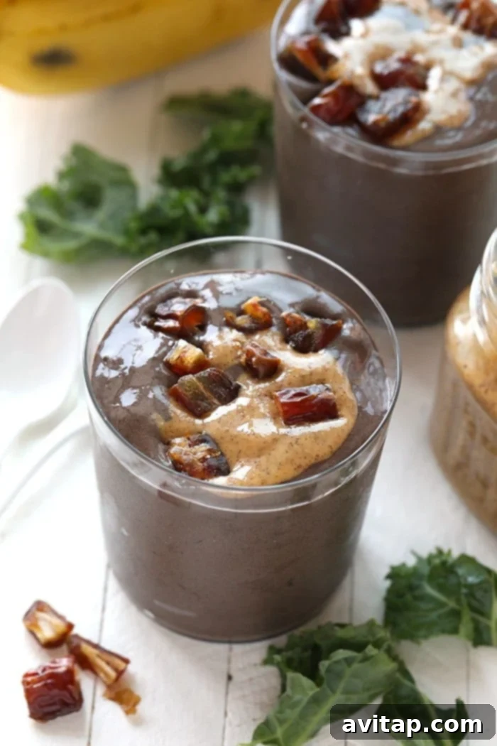 Delicious Dark Chocolate Date Protein Smoothie in a glass, garnished with chopped dates and a spoon, ready to be enjoyed.