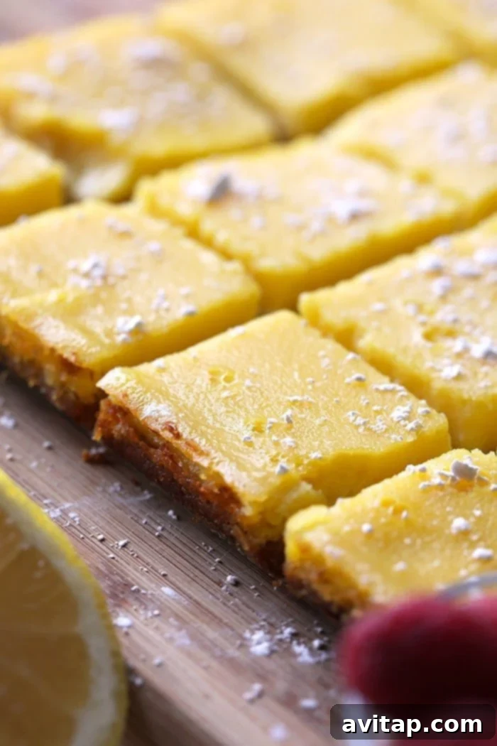 Several healthy gluten-free lemon bars dusted with powdered sugar, ready for serving.