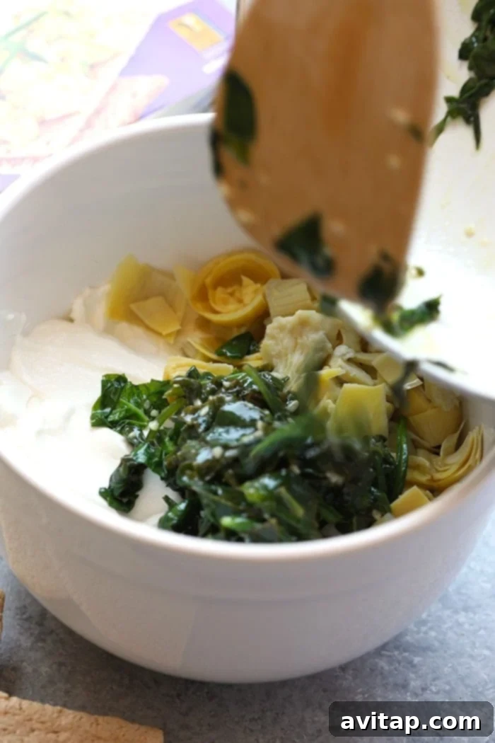 Enjoy this AMAZING lightened-up, restaurant-style Healthy Spinach and Artichoke Dip for a nutrition-packed snack or appetizer all year round. This spinach and artichoke dip will quickly become a crowd-pleasing recipe you'll make again and again. All the fresh and wholesome ingredients laid out for preparing the healthy spinach artichoke dip.