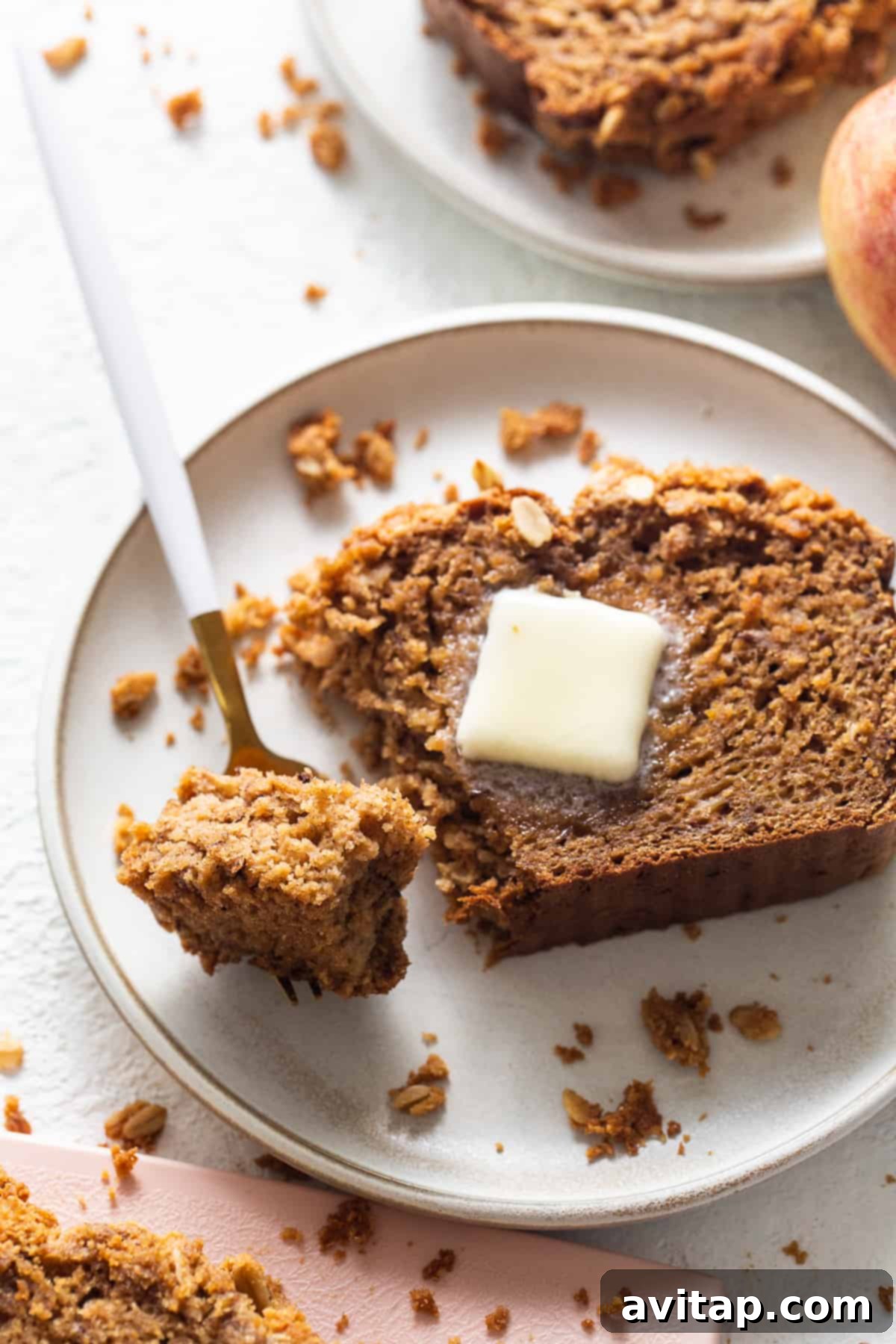Three golden-brown slices of Peanut Butter Apple Streusel Bread on a cutting board, ready for serving.
