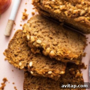 A vibrant image of three slices of Peanut Butter Apple Streusel Bread artfully arranged on a pink surface.