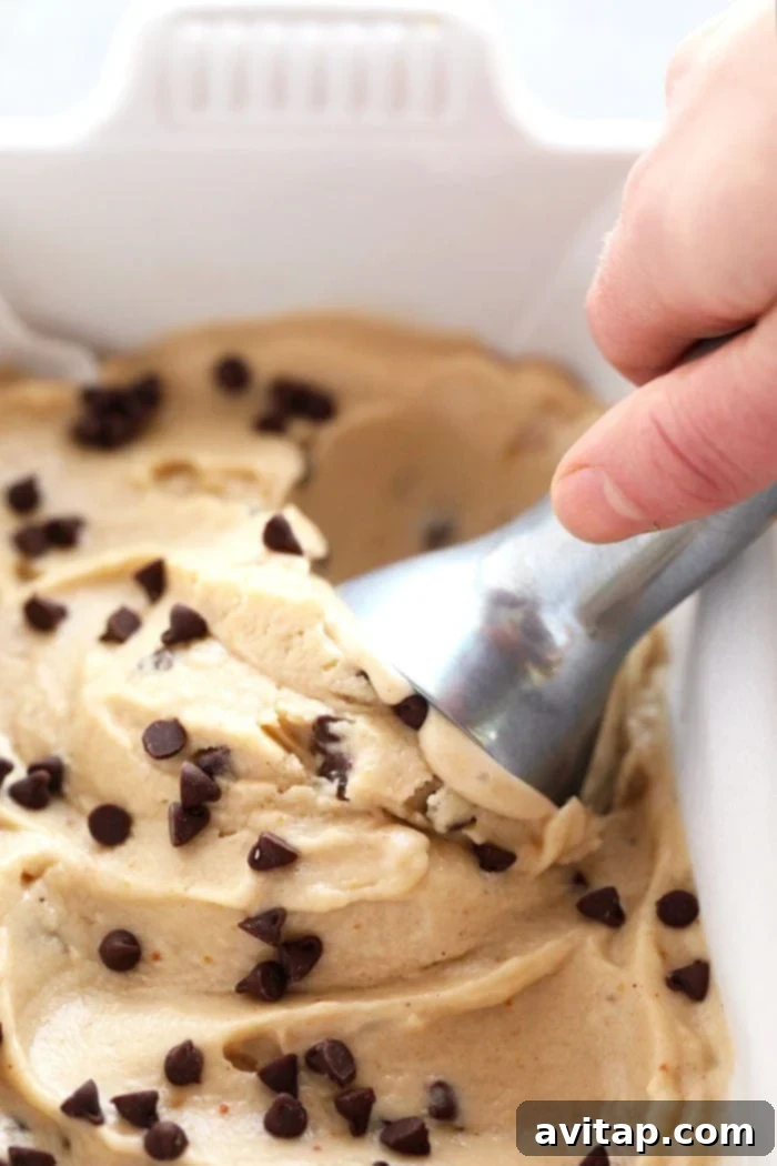 A scoop of rich peanut butter banana nice cream being served from a loaf pan, showcasing its perfect texture.