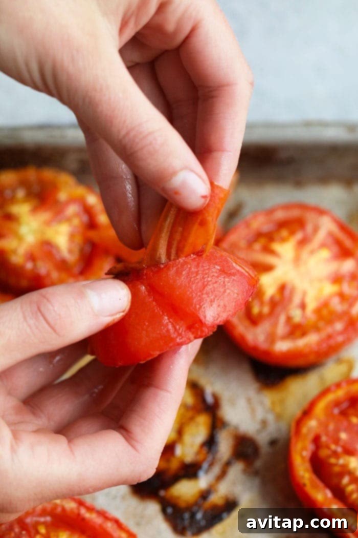 For this Roasted Tomato Basil Marinara Sauce recipe, you'll only need a few ingredients with no added sugar! Close-up of peeling skin off a roasted tomato.
