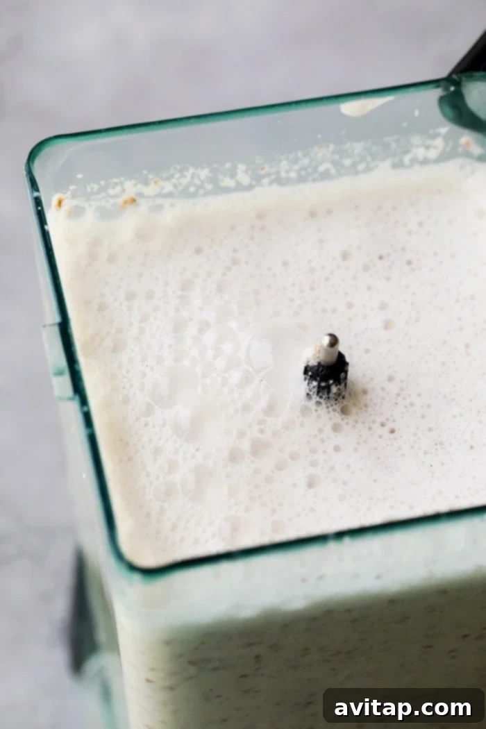 Creamy almond milk mixture and fine almond pulp swirling in a high-speed blender after blending.