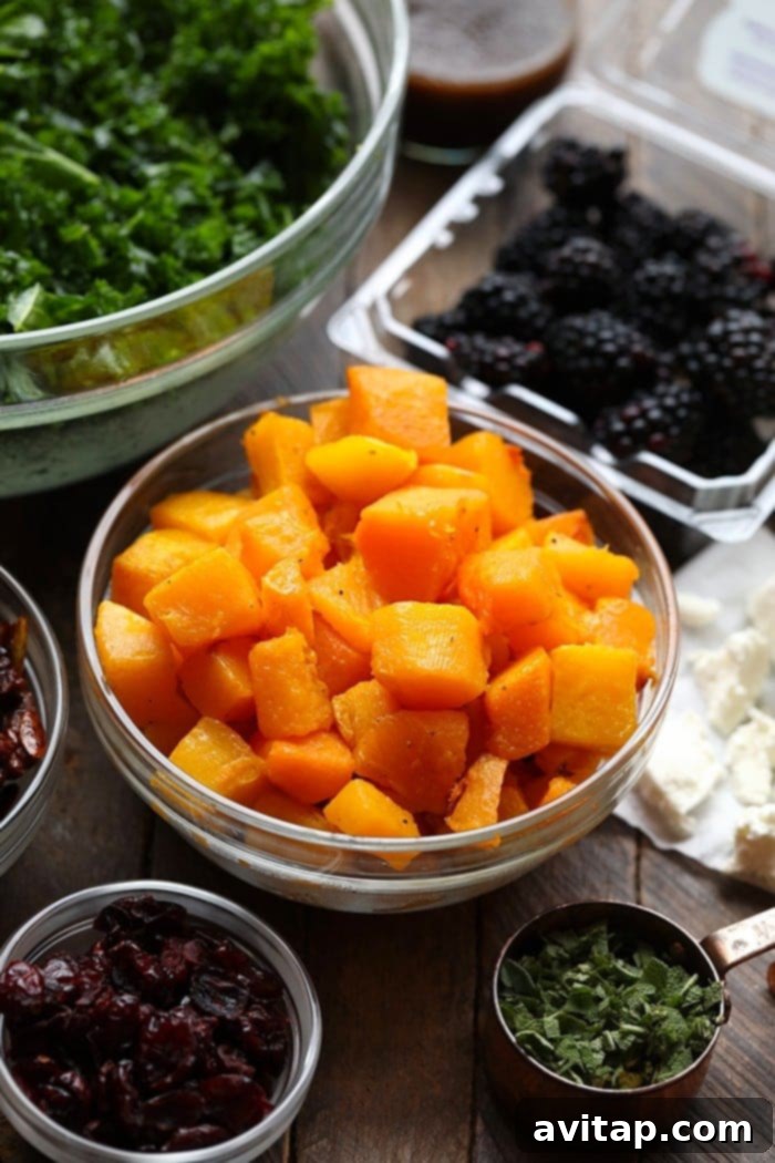 A bowl filled with freshly roasted, caramelized butternut squash cubes, ready to be added to a salad.